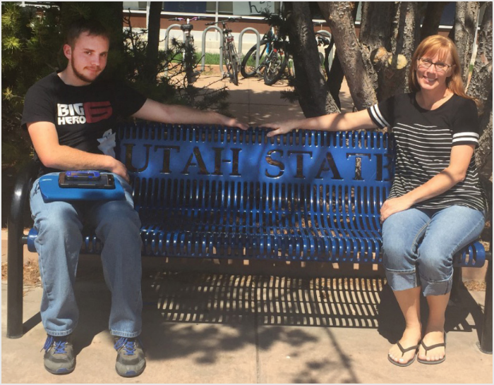 Bryce sitting on a bench at Utah State University